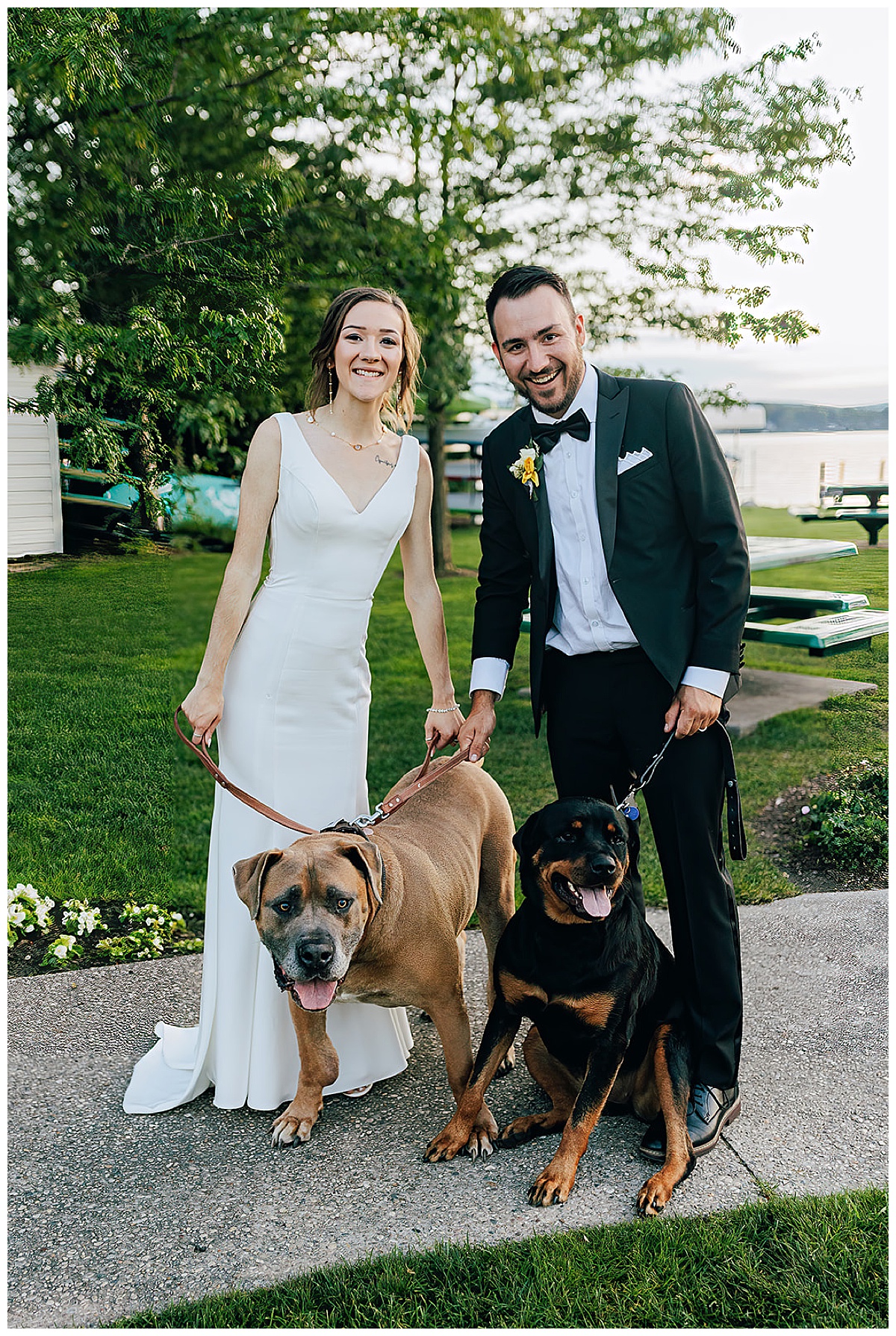 Couple smile with leashed dogs for Detroit Wedding Photographer
