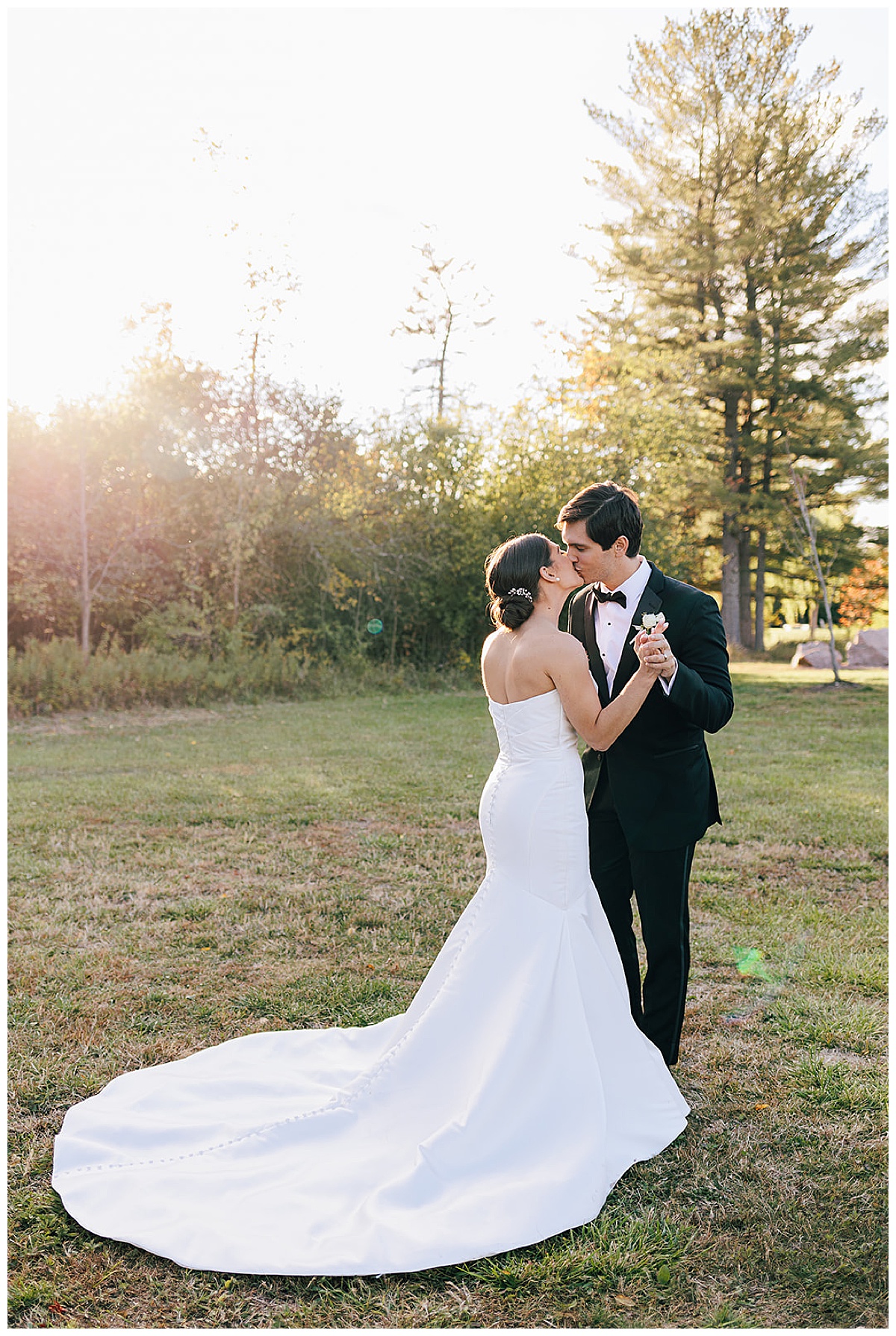 Bride and groom share a kiss on the grass for Kayla Bouren Photography