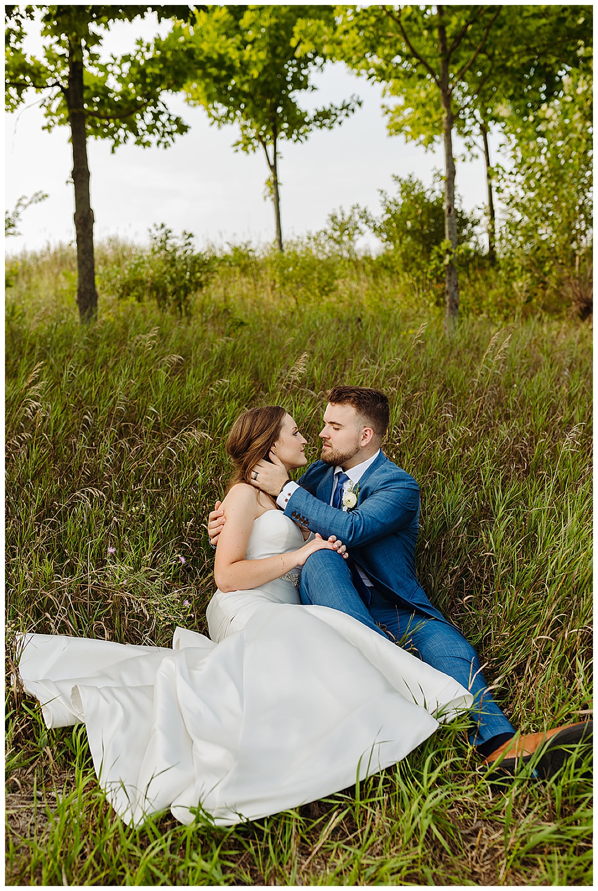 Husband and wife embrace on a hillside for Bayview Weddings