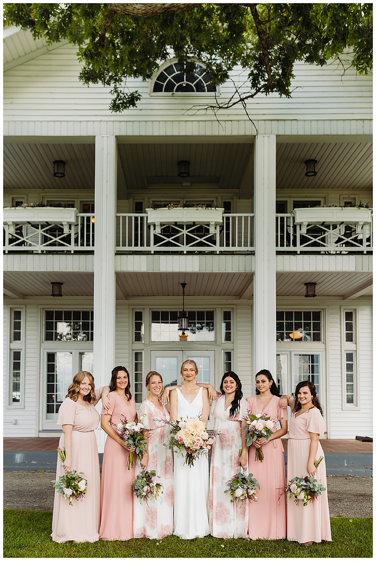Bride and bridesmaids stand close and smile big at Walden Woods