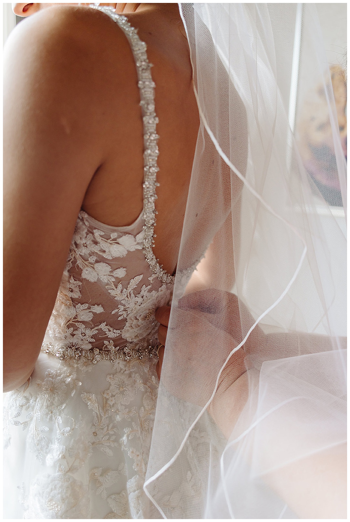 Woman adjusts bride's dress at Meeting House Grand Ballroom