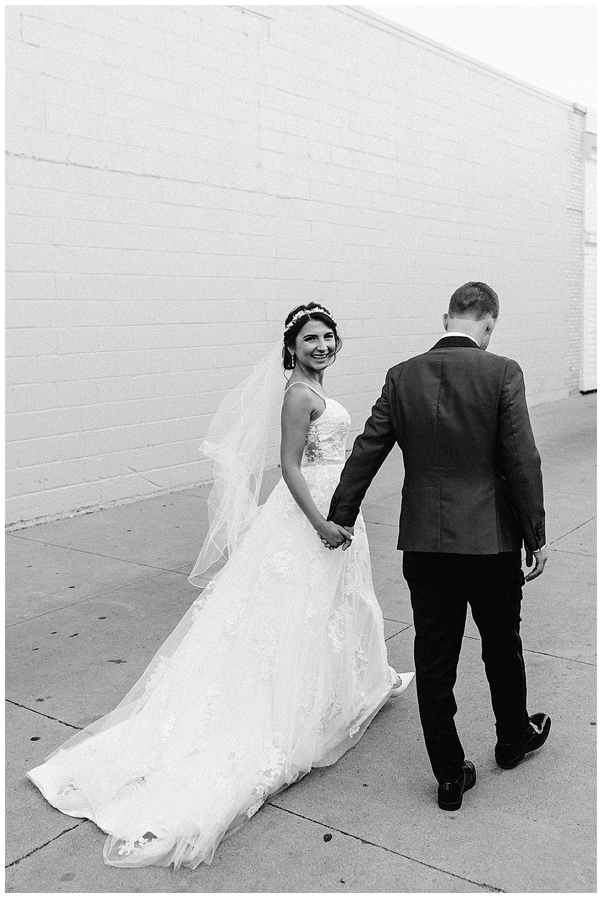 Woman holds mans hand walking for Detroit Wedding Photographer