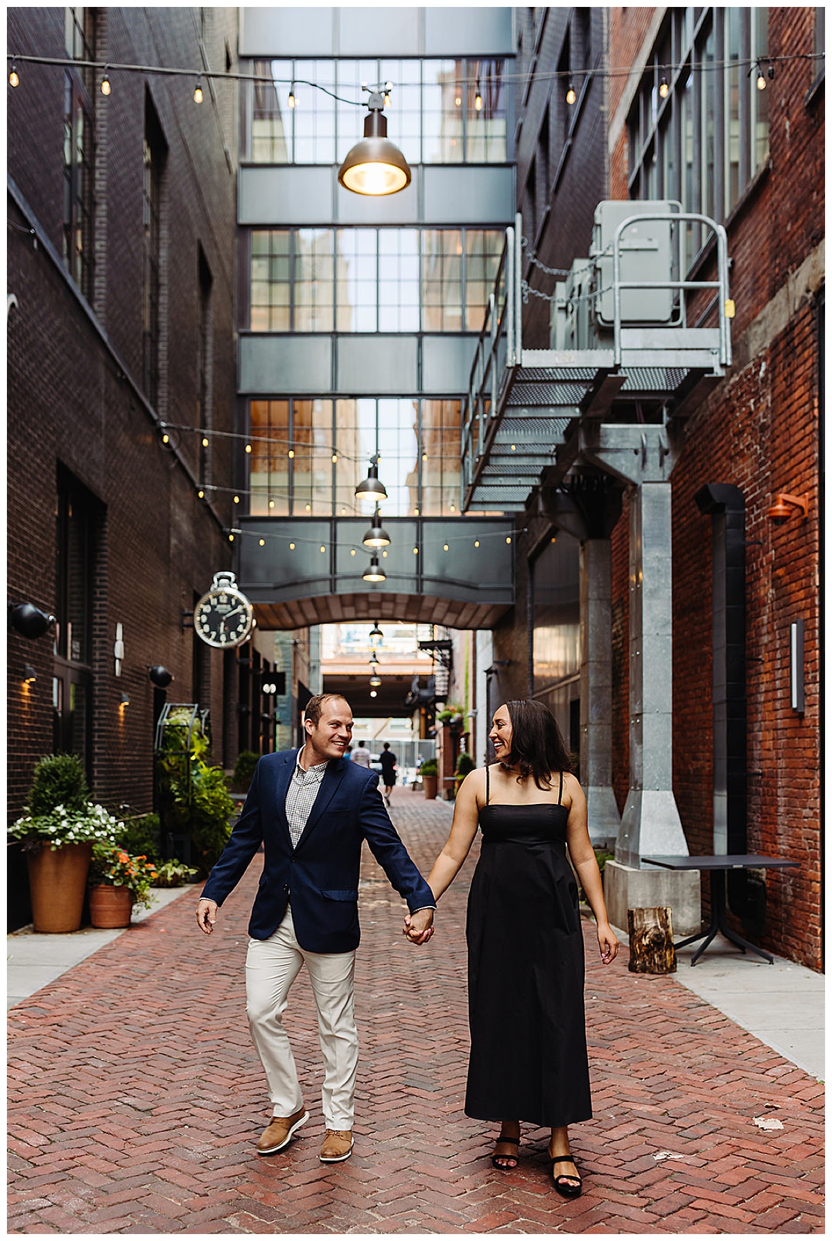 Engaged couple hold hands under lights during Woodward Ave. engagement session