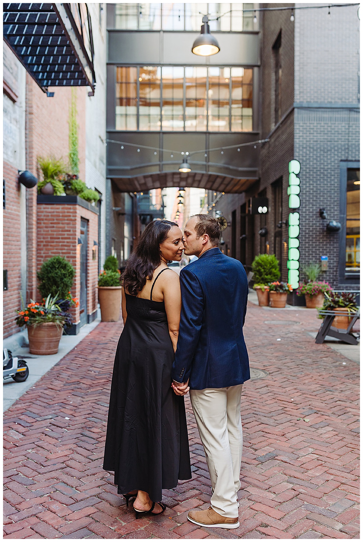 Man kisses woman in front of lights for Detroit Wedding Photographer