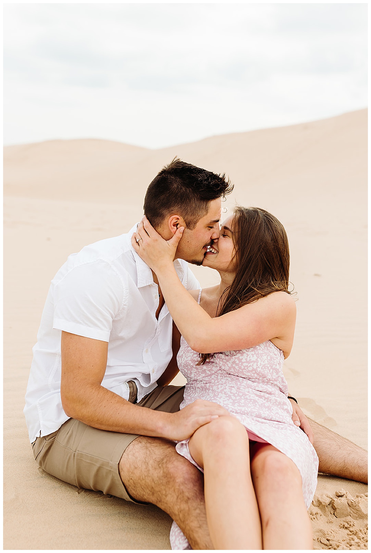 Woman holds man close for a kiss for Kayla Bouren Photography