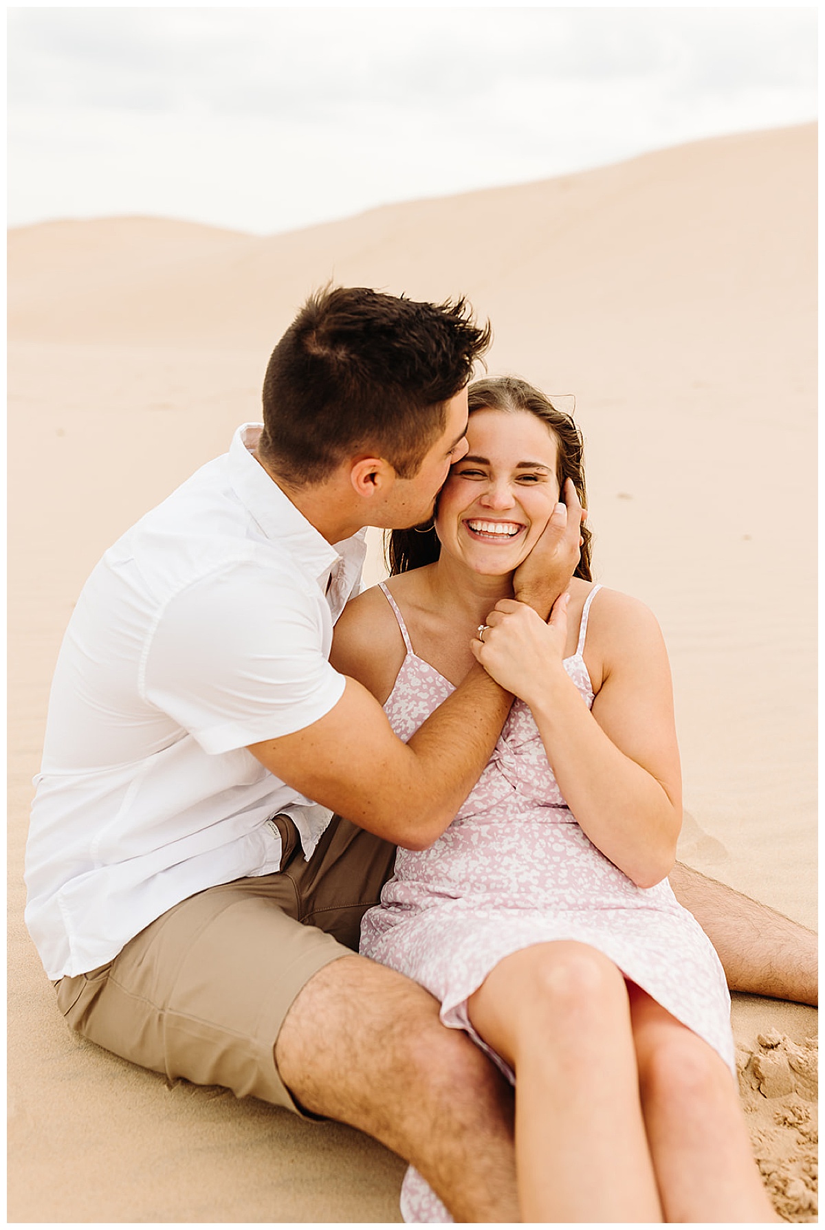 Guy kisses girl on cheek during Mears, MI Engagement session