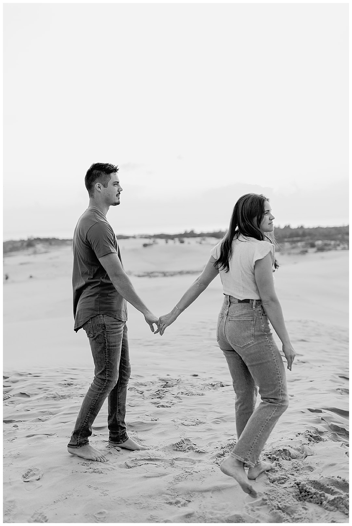 Couple walk hand in hand in sand for Detroit Wedding Photographer