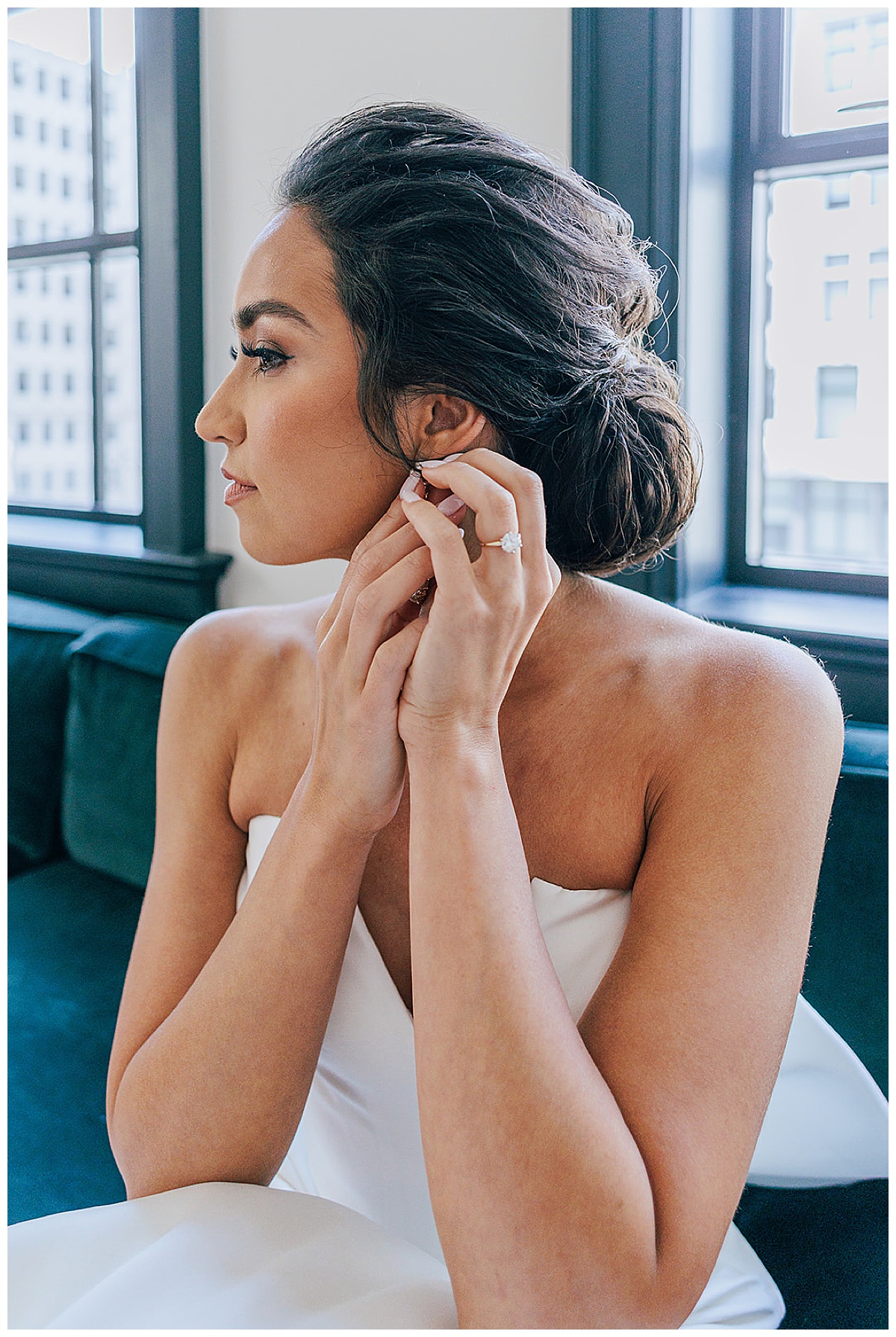 Stunning bride adjusts her wedding earrings for Kayla Bouren Photography