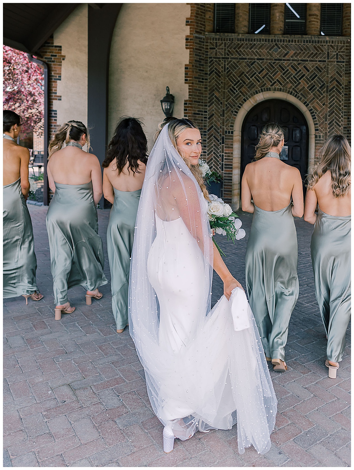 Bride walks with bridesmaids for Kayla Bouren Photography