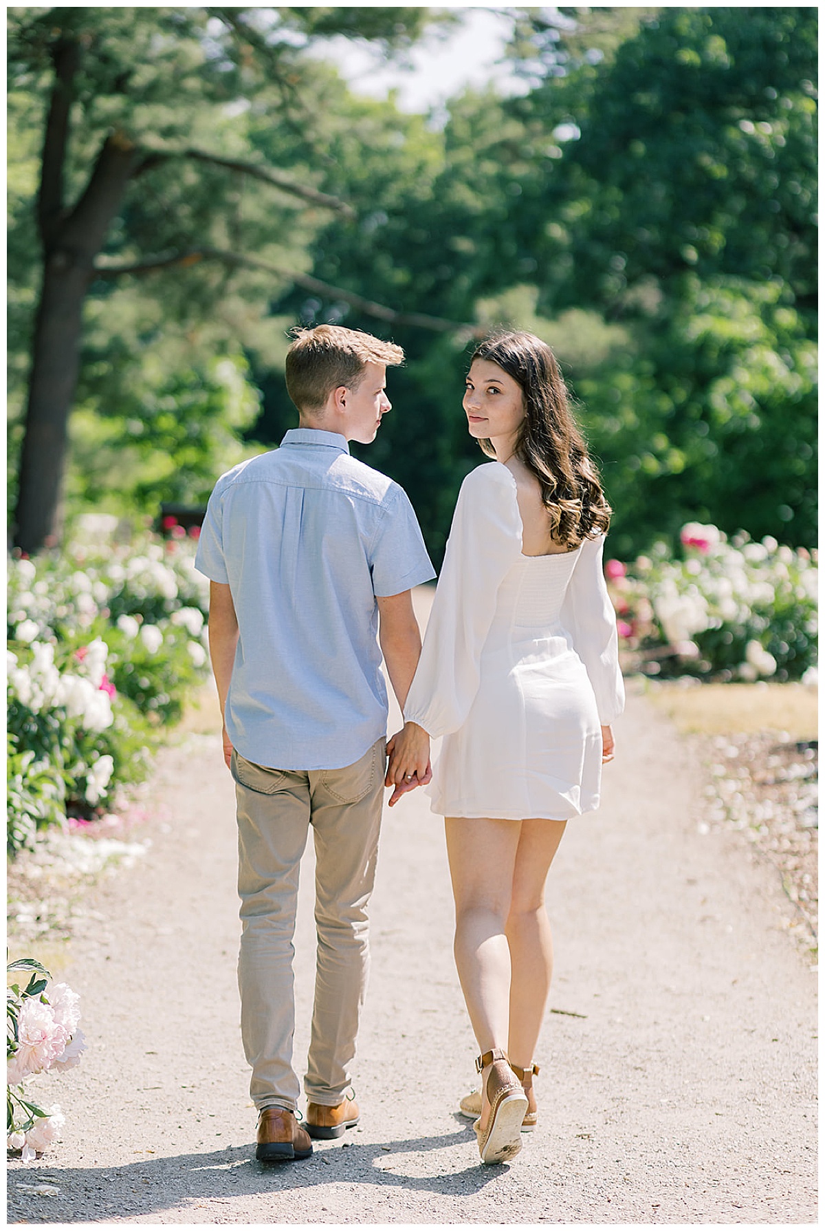 Couple walk hand in hand for Ann Arbor peony garden engagement session