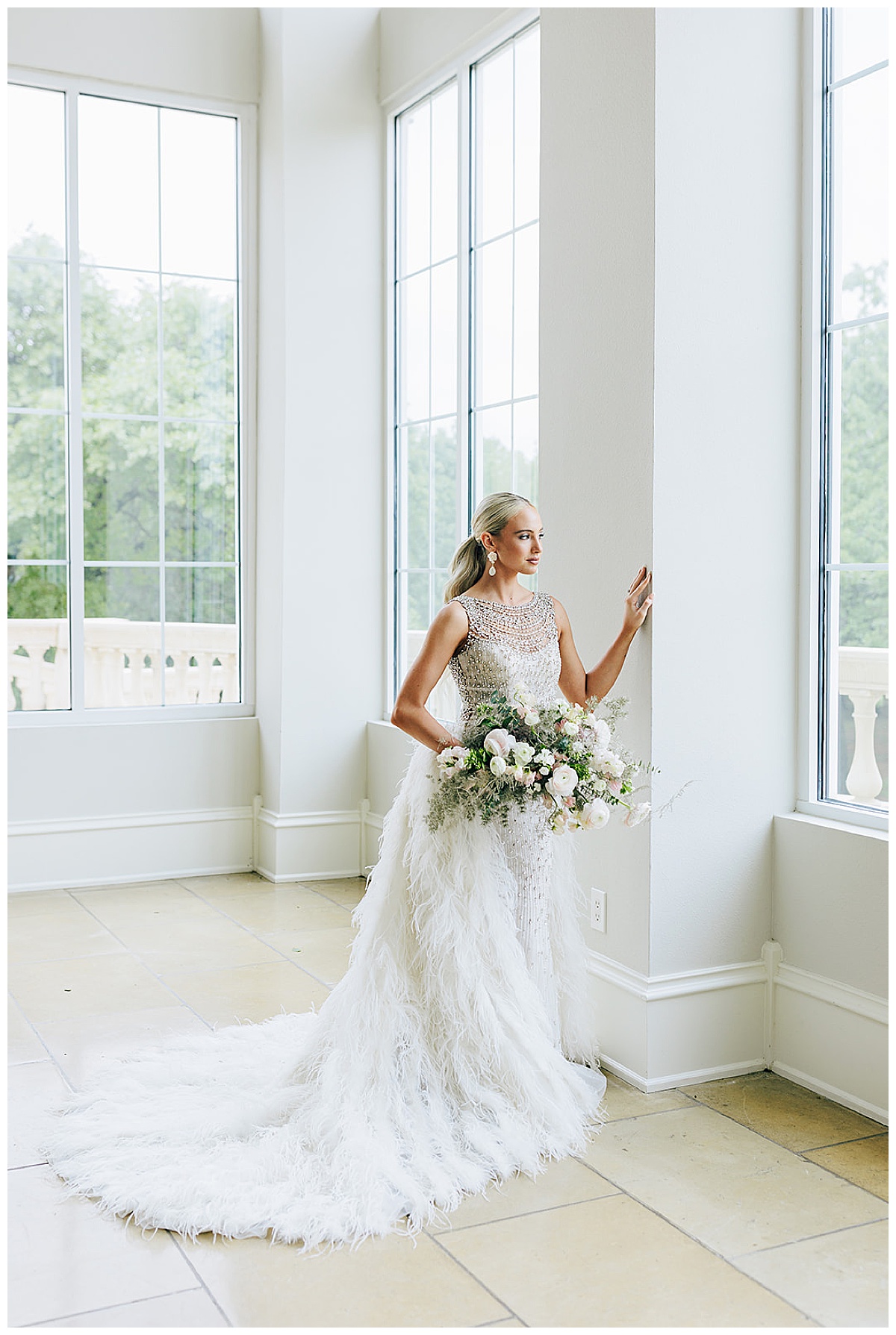 Bride stands near window for Kayla Bouren Photography