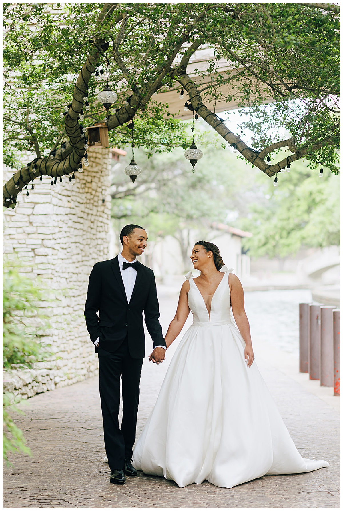 Man and woman walk hand in hand together smiling and laughing for Kayla Bouren Photography