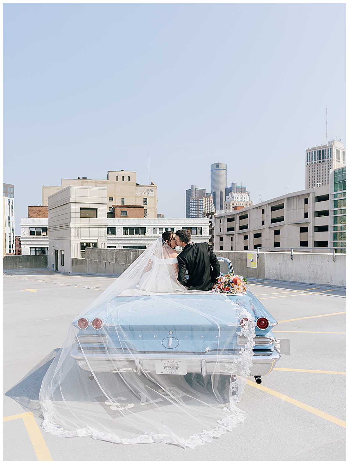 Couple share a kiss while sitting on vintage car for Detroit Wedding Photographer