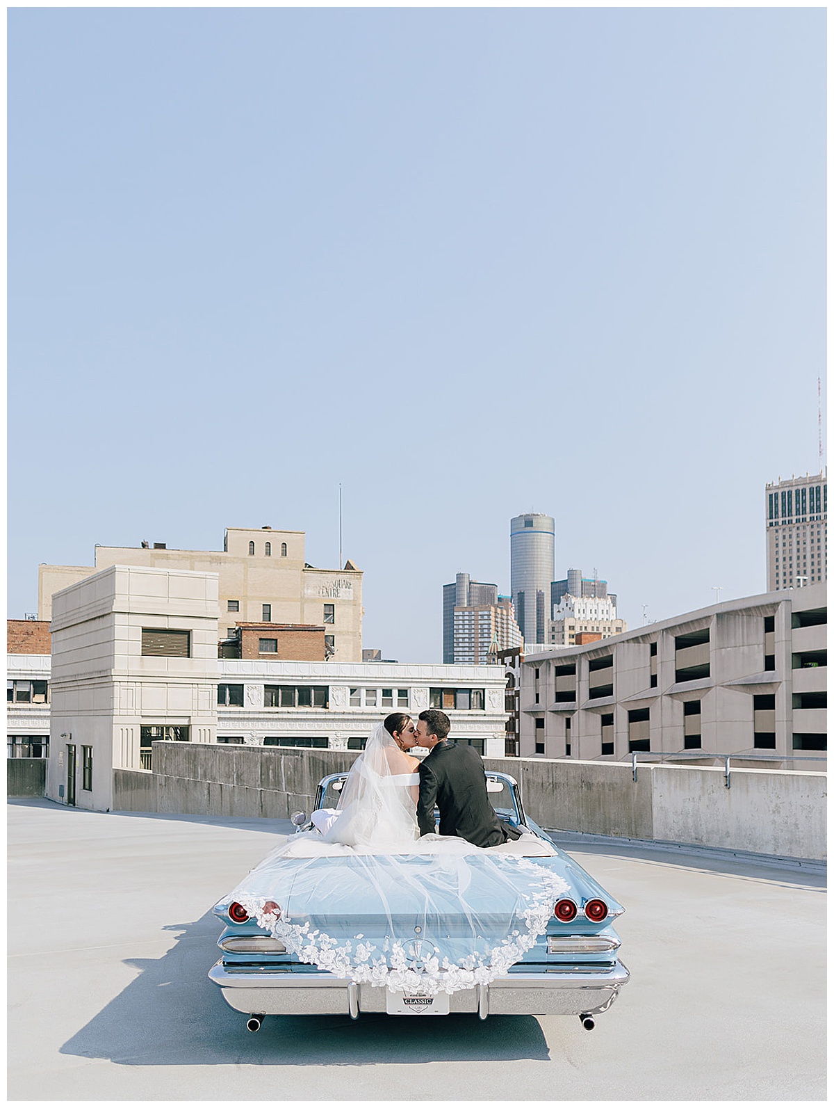 husband and wife share a kiss while sitting on luxury car for Detroit Wedding Photographer