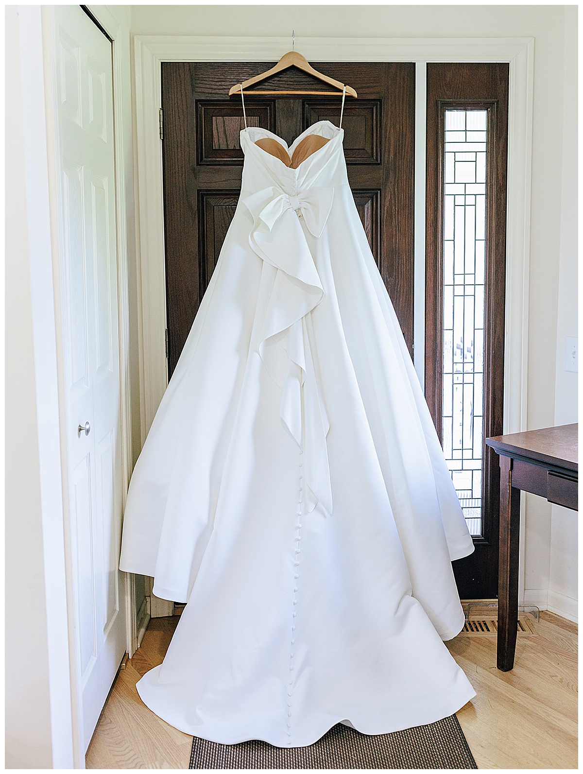 Wedding dress hangs on door for Kayla Bouren Photography