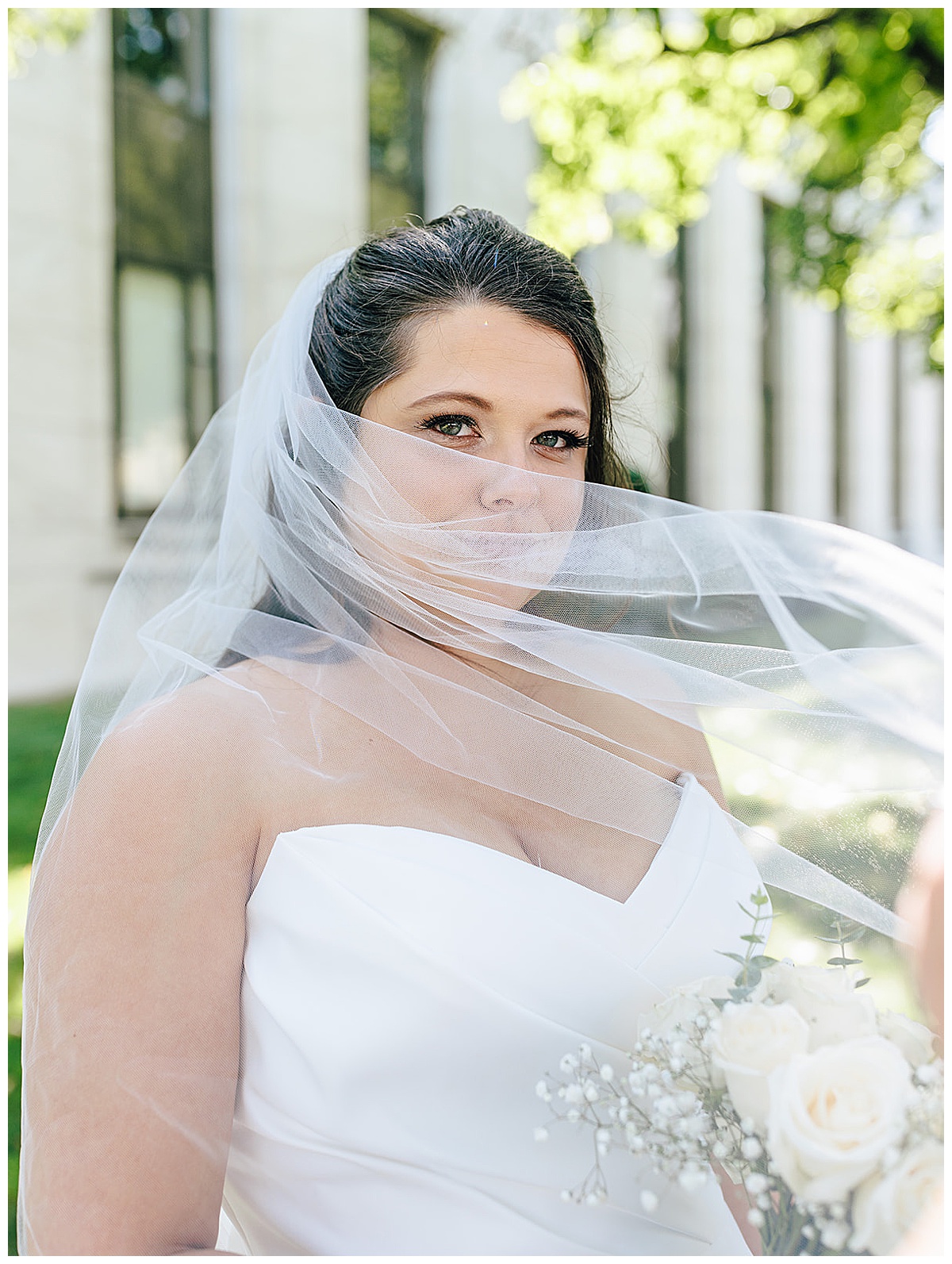 Bride pulls veil in front of her face for Kayla Bouren Photography